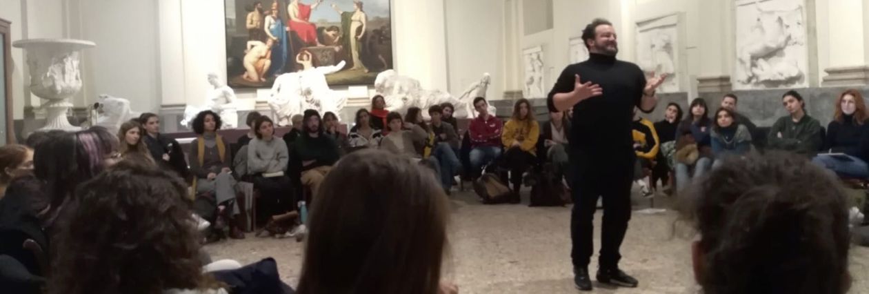 Massimiliano Cividati parla agli studenti seduti in cerchio nella gipsoteca dell'Accademia di Brera