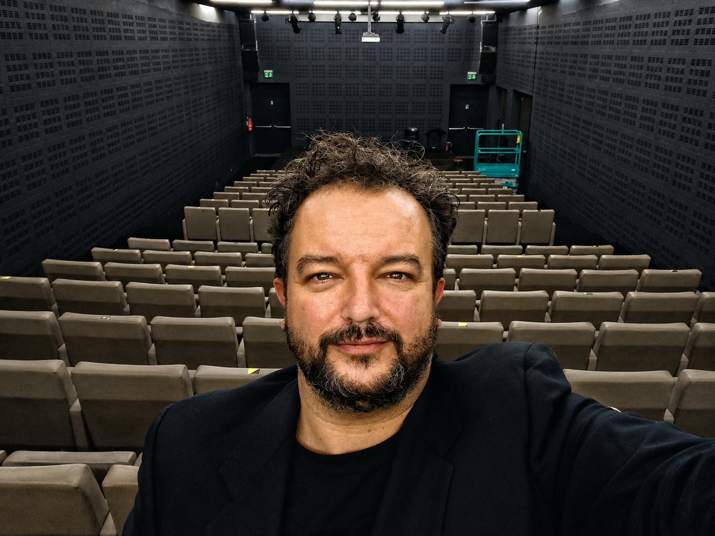 Massimiliano Cividati seduto in platea, in un teatro vuoto